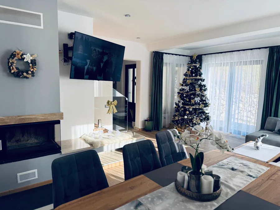Christmas dining area with tree and active fireplace